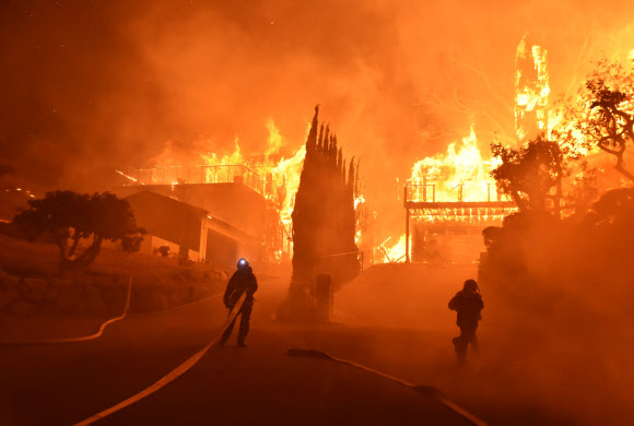 캘리포니아 또 통제불능 산불…2만 7000여명 대피 - 미국 캘리포니아주 로스앤젤레스 북쪽 도시 벤추라와 실마카운티에서 초대형 산불이 발생해 소방대원들이 5일(현지시간) 불이 옮겨붙은 주택가에 출동해 진화작업을 벌이고 있다. 산불은 시속 80㎞의 강풍을 타고 빠르게 번져 건물 150채가 전소되고 주민 2만 7000여명이 대피했다. 건조한 날씨에 산불 진화가 어려운 상황에 처하자 제리 브라운 캘리포니아 주지사는 비상사태를 선포했다.로스앤젤레스 AP 연합뉴스
