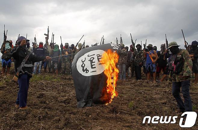 지난해 필리핀 남부 민다나오섬에서 이슬람국가(IS) 상징기를 불태우는 기독교 무장 집단. © AFP=뉴스1