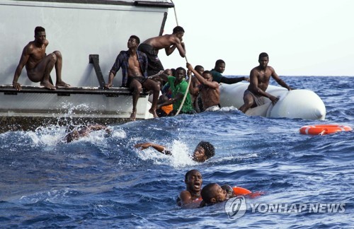 리비아 해안에서 해안 경비대의 구명선에 올라타는 난민들 [AP=연합뉴스 자료사진]