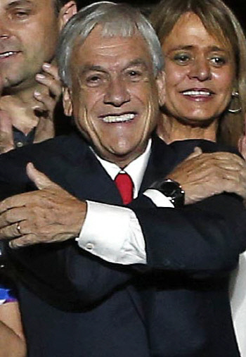 칠레 중도 우파 야당연합 세바스티안 피녜라 후보가 17일(현지시간) 대선 결선 투표에서 당선이 확정된 뒤 지지자들 앞에서 포옹하는 모습을 취하며 웃고 있다.  산티아고 | AP연합뉴스