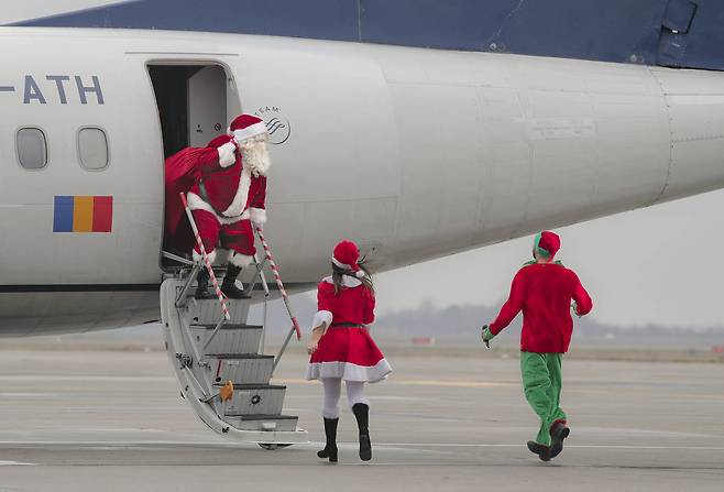 19일(현지시간) 루마니아의 부카레스트에서 열릴 예정인 크리스마스 행사에 참석하기 위해 앙리 코 안다 공항에 착륙한 비행기에서 내리는 산타클로스.[AP=연합뉴스]