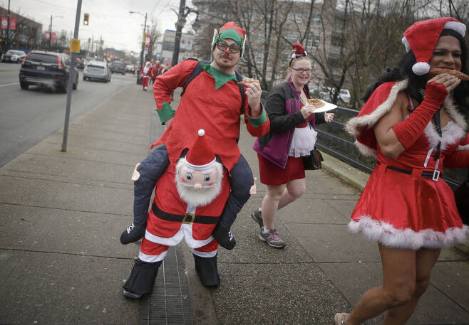 17일(현지시간) 캐나다 밴쿠버에서 열린 산타 콘 이벤트에 참여한 한 시민이 이색 산타 클로스 차림을 하고 거리를 지나고 있다. 매년 열리는 산타콘은 행사 당일 참여자 모두가 산타 등의 크리스마스 복장을 하고 크리스마스 분위기를 즐기며 기부하는 이벤트다.[신화=연합뉴스]