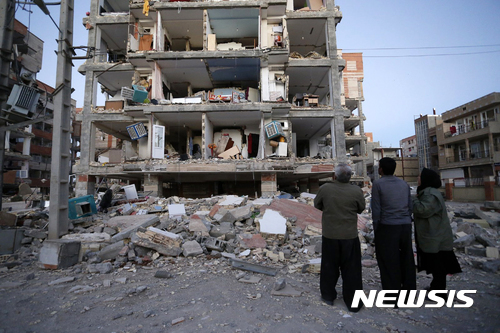 【사르폴자하브=ISNA·AP/뉴시스】 이란 사르폴자하브에서 13일(현지시간) 주민들이 강진으로 무너진 건물을 바라보고 있다. 사진은 이란 현지 언론인 ISNA가 제공한 것이다.  2017.11.13