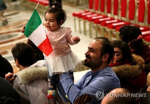 교황 초청 미사에 참석해 이탈리아 국기를 흔드는 이주민 어린이 [로이터=연합뉴스]