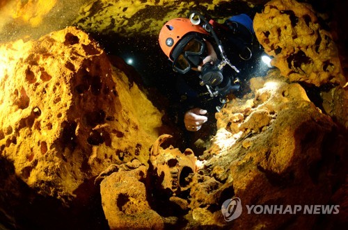 삭 악툰 수중동굴에서 동물 두개골을 살펴보는 잠수사 [로이터=연합뉴스]