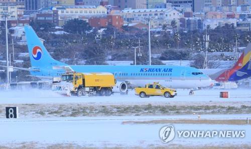 제주공항 활주로 제설 (제주=연합뉴스) 박지호 기자 = 폭설이 내린 11일 오전 제설차량이 제주국제공항 활주로에서 눈을 치우고 있다. 2018.1.11 jihopark@yna.co.kr