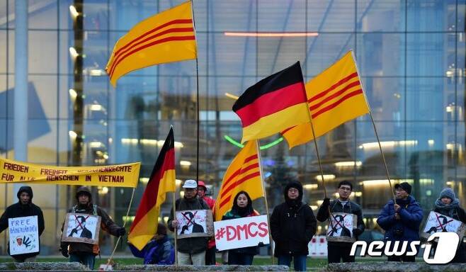2015년 독일 베를린에서 당시 쯔엉 떤 상 국가주석의 방문을 반대하는 시위가 벌어졌다. 시위대가 과거 남베트남의 국기를 들고 있다.  © ASFP=News1