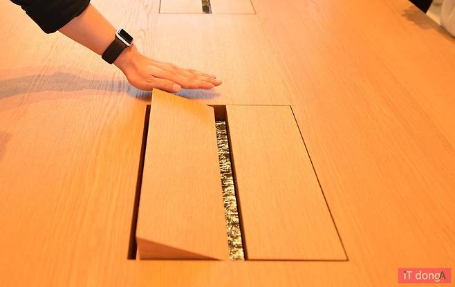 테이블 가운데 손을 가져가면 전원을 충전할 수 있는 박스가 서서히 올라온다