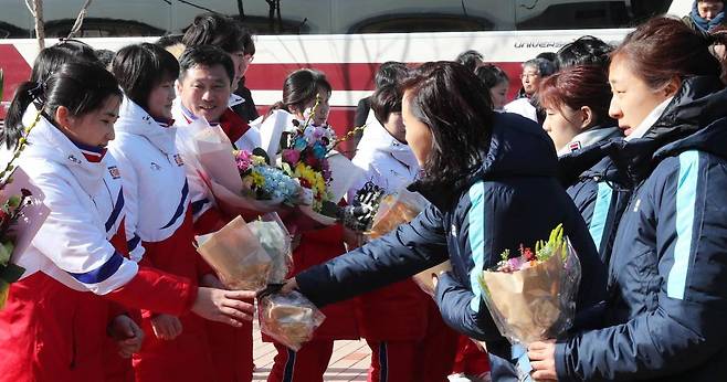 북한 여자 아이스하키 선수단이 지난 25일 오후 충청북도 진천군 국가대표선수촌 빙상훈련장에 도착해 환영식을 하고 있다. 한국 선수들이 북한 선수들에게 꽃다발을 주고있다./사진=공동취재단