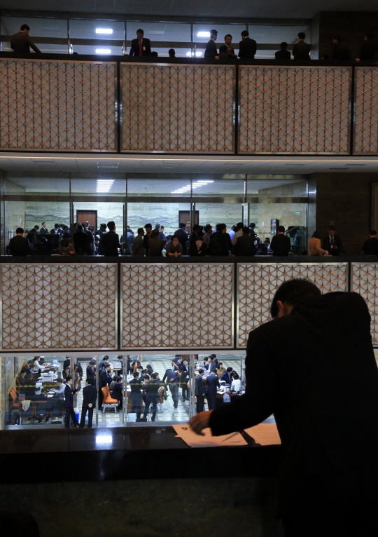 지난해 10월 국회의 국정감사를 앞두고 공무원들이 국감장 앞에서 자료를 보면서 질의 순서를 기다리고 있다. /연합뉴스