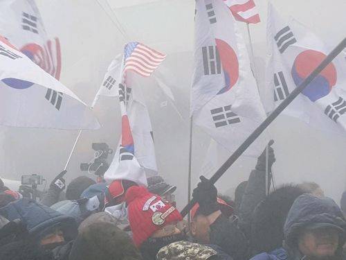 대한애국당은 이날 오후 2시 서울 동대문디지털플라자(DDP) 앞에서 '평양올림픽 반대 박근혜 무죄 석방 태극기집회'를 열었다. 집회 참가자들이 한반도기와 인공기를 불태우자 경찰이 소화기를 뿌려 이를 진화하는 모습.(사진=연합뉴스)