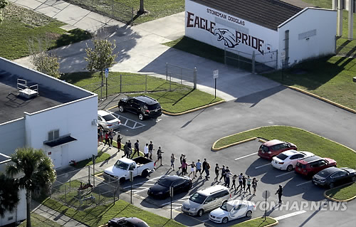 지난 14일(현지시간) 총기 난사 사건이 발생한 미국 플로리다 주 마조리 스톤맨 더글러스 고교에서 학생들을 인솔해 대피시키는 모습[AP=연합뉴스]