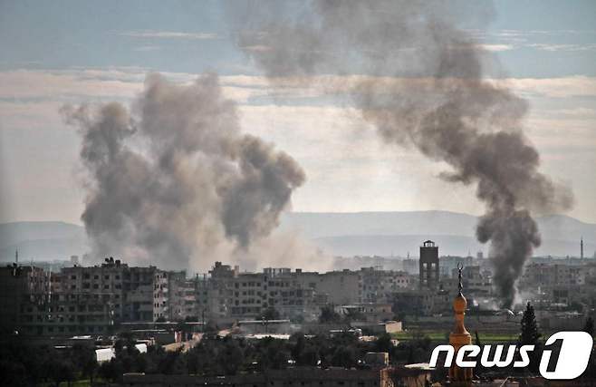 19일(현지시간) 시리아 정부군의 공격을 받은 동구타에서 뿌연 연기가 피어오르고 있다. © AFP=뉴스1