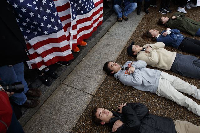 지난 19일(현지시간) 미국 워싱턴DC 백악관 앞에서 총기규제 강화를 요구하는 학생들이 '드러눕기' 퍼포먼스를 하며 항의 시위를 벌이고 있다.  AP 연합뉴스