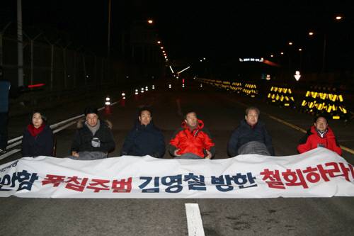 24일 오후 자유한국당 김무성 김영철방한저지투쟁위위원장, 김성태 원내대표(오른쪽 두번째부터) 등 한국당 의원들이 김영철 북한 노동당 대남 담당 부위원장 겸 통일전선부장의 방남 철회를 주장하며 경기 파주 통일대교 위에서 연좌농성하고 있다. 연합뉴스