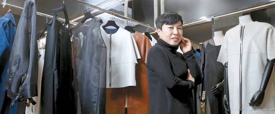 지난달 13일 청담동 ‘데무’ 사옥에서 만난 박춘무 디자이너. 60대의 나이가 무색할 만큼 에너지가 넘치는 그는 늘 그랬듯 머리끝부터 발끝까지 검은색 옷을 입고 20~30대를 겨냥해 만든 ‘데무 Y라벨’ 옷을 배경으로 포즈를 취했다. 강정현 기자