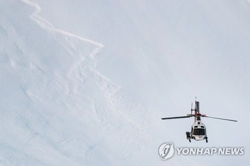 지난달 18일(현지시간) 스위스 피노 지역 눈사태 현장에서 헬리콥터가 떠 있다. [EPA=연합뉴스]