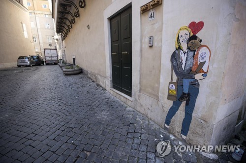 이탈리아 극우당 이탈리아형제당의 조르지아 멜로니 대표가 흑인 아이를 안고 있는 모습을 담은 벽화가 23일 로마 시내에 등장했다. [EPA=연합뉴스]