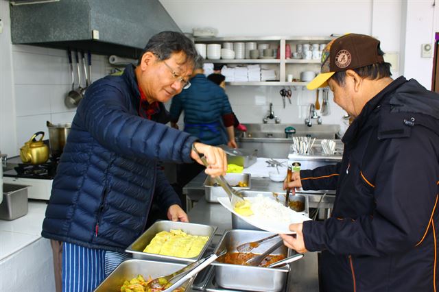서영남(왼쪽) 민들레국수집 대표가 지난 26일 식당을 찾은 한 노숙자에게 직접 배식을 하고 있다.