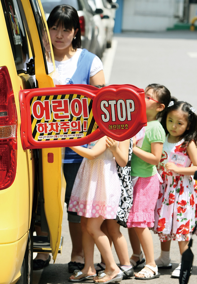 2008년 6월 서울 서대문구청에서 열린 어린이 승하차 보호기 장착 및 시연회에서 어린이들과 선생님이 어린이 전용 승합차에 장착된 보호기를 활용해 승하차 연습을 하고 있다. © 사진=연합뉴스