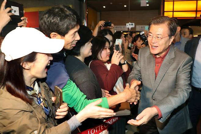 문재인 대통령이 지난해 10월15일 부산국제영화제를 방문해 영화 '미씽'을 관람한 뒤 관객들과 손을 잡고 있다. 청와대사진기자단