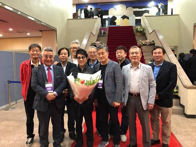 조용필 50주년 기념 무대를 축하하기 위해 모인 전 위대한 탄생 멤버들. 앞줄 좌로부터 김희현, 조용필, 송홍섭, 김청산, 김광민, 뒷줄 좌로부터 김택환, 이건태, 김종진, 유상윤, 유영선