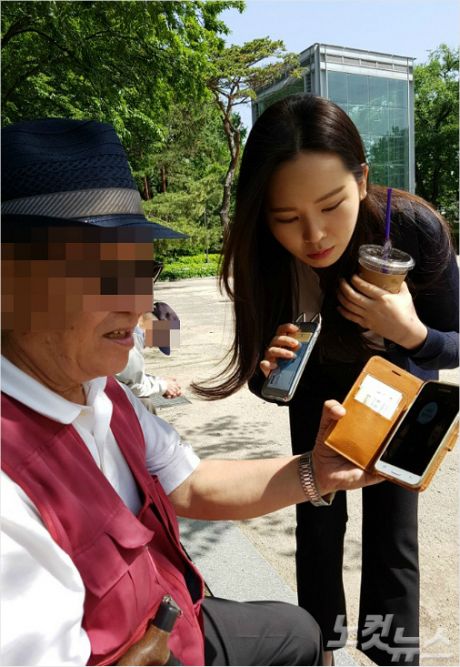 서울 종로구 탑골공원에서 만난 이모씨가 취재 기자에게 카카오톡 메시지를 보여주고 있다.