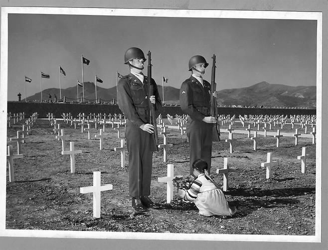 1951. 4. 부산, 한 소녀가 유엔군 묘지에 헌화하고 있다. ⓒNARA
