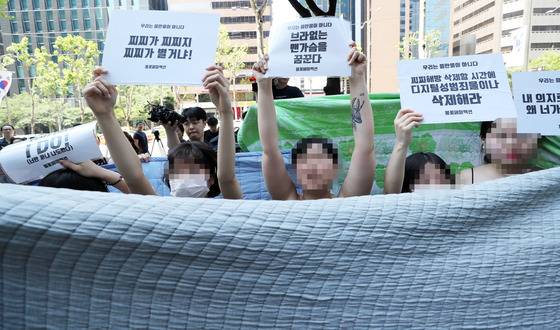 불꽃페미액션 활동가들이 2일 오후 서울 강남구 페이스북코리아 사옥 앞에서 성차별적 규정에 맞서는 상의탈의 퍼포먼스를 벌이다 경찰에게 제지 당하고 있다. 이 단체는 페이스북이 남성의 나체 사진은 제제를 가하지 않으면서 여성의 나체 사진만 삭제하는 것에 항의하기 위해 이번 시위를 진행했다./사진=뉴스1