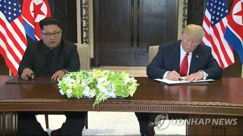 역사적 첫 북미정상회담이 열린 12일 오후 싱가포르 센토사 섬 카펠라호텔에서 미국 도널드 트럼프 대통령(오른쪽)과 북한 김정은 국무위원장이 합의문에 서명하고 있다. [AP=연합뉴스]