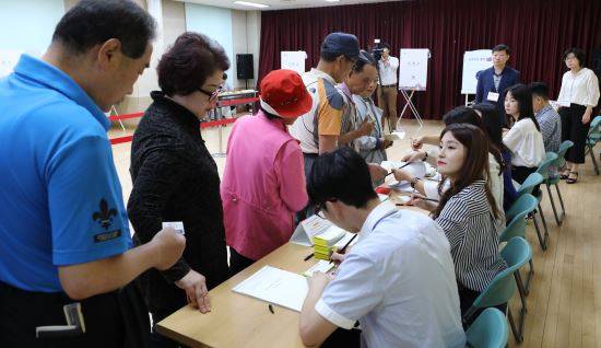 제7회 전국동시지방선거 및 국회의원 재·보궐 선거일인 13일 오전 서울 종로구 숭인1동 주민센터 투표소에서 시민들이 투표를 하기 위해 신분증 확인을 하고 있다. 이하 뉴시스