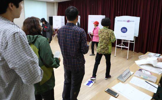 제7회 전국동시지방선거 및 국회의원 재·보궐 선거일인 13일 오전 서울 종로구 숭인1동 주민센터 투표소에서 시민들이 투표를 하고 있다.
