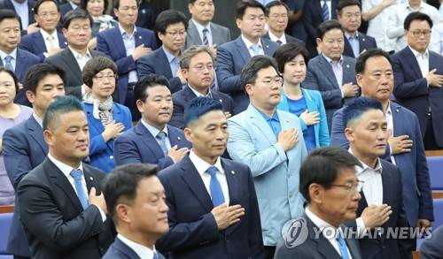 국기에 경례하는 파란머리 의원들 (서울=연합뉴스) 김주형 기자 = 14일 오후 국회에서 열린 더불어민주당 의원총회에서 짧고 파란색으로 머리를 염색한 의원들이 국기에 경례하고 있다. 이들은 6.13 지방선거 투표율이 60%를 넘을 경우 머리를 짧게 깎고 파란색 염색을 하겠다고 공약한 바 있다. kjhpress@yna.co.kr