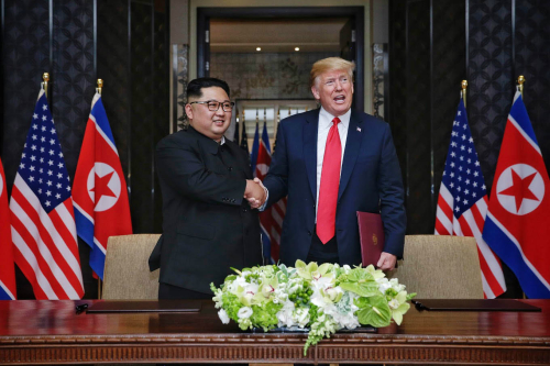 12일 김정은 북한 국무위원장과 도널드 트럼프 미국 대통령이 싱가포르 센토사섬 카펠라 호텔에서 북미정상회담 합의문 서명하고 악수를 하고 있다.