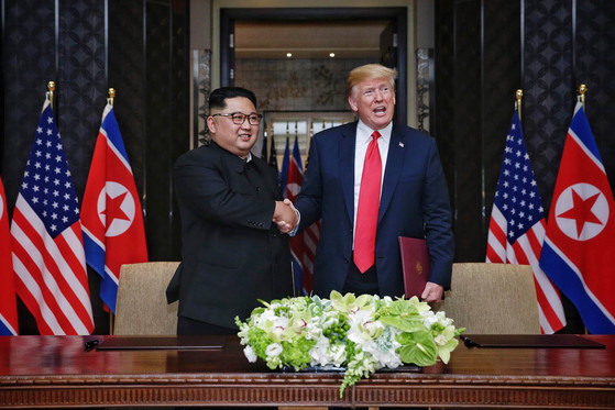 북미정상회담 합의문에 서명한 뒤 악수하는 김정은 국무위원장과 도널드 트럼프 미국 대통령 (싱가포르 통신정보부 제공)