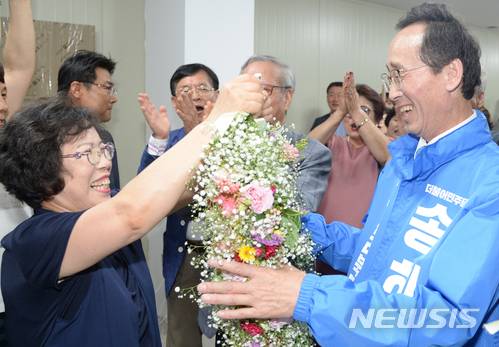 【전주=뉴시스】 김얼 기자 = 제7회 전국 동시지방선거 본 투표가 끝난 13일 더불어민주당 송하진 전북도지사후보가 전북 전주시 완산구 평화동 후보 선거사무소에서 당선이 확실시 되자 지지자에게 꽃목걸이를 받으며 환하게 웃고 있다. 2018.06.13pmkeul@newsis.com