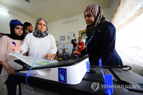 전자 투개표 시스템에 투표용지를 넣는 이라크 유권자[DPA=연합뉴스자료사진]