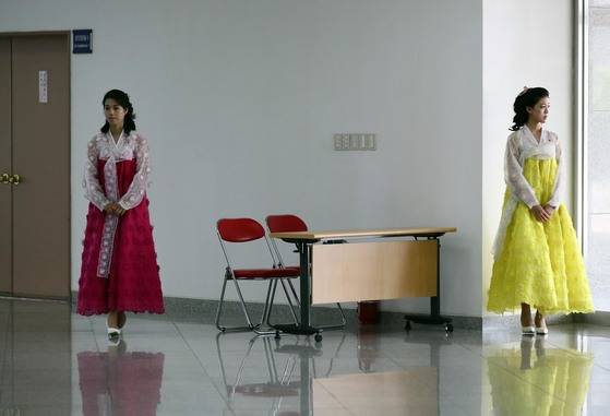 꽃 장식을 단 한복을 입은 북한 봉사원들이 4일 남북통일농구경기가 열리는 평양 류경 정주영체육관에서 손님을 기다리고 있다. 사진공동취재단