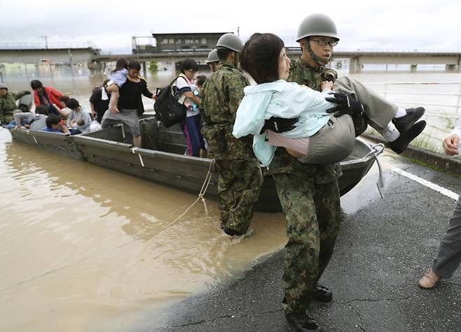 폭우로 물에 잠긴 일본 오카야마(岡山)현 구라시키(倉敷)시 마비초(眞備町) 마을에서 자위대원이 보트를 이용, 고립된 주민들을 구조하고 있다. 교도연합