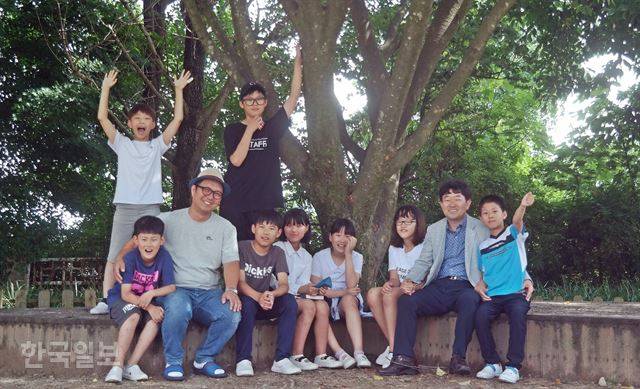 지난달 27일 전북 임실군 신평면 대리마을 대리초 운동장 나무그늘에 유학생들과 마을 학생, 양성호(왼쪽 세 번째) 교사, 김호경(오른쪽 두 번째) 교장이 둘러 앉았다. "(사진) 다 됐습니다"라는 기자의 말이 떨어지기 무섭게 아이들은 "저기 개구리 있다!"를 외치며 흩어졌다. 임실=김혜영기자