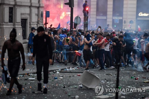 파리 샹젤리제 거리에서 시민들이 프랑스의 월드컵 우승에 환호하는 가운데 일부 청년들이 상점을 부수고 돌을 던지며 경찰과 대치했다. [AFP=연합뉴스]