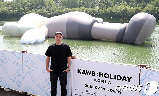 팝 아티스트 카우스가 19일 서울 잠실 석촌호수에 설치된 공공미술 프로젝트인 '카우스: 홀리데이 코리아' 작품을 배경으로 포즈를 취하고 있다. 2018.7.19/뉴스1 © News1 김명섭 기자