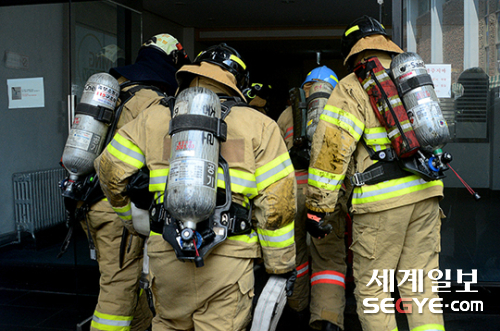 서울 낮 최고 기온이 35도까지 치솟는 등 폭염 특보가 내려진 지난 20일 오후 서울 도심 속 화재현장에서 진화작업을 하기 위해 소방대원이 건물 내부로 들어가고 있다.