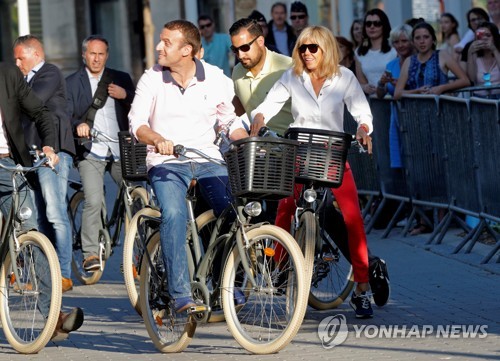 지난 6월 자전거를 탄 모습의 에마뉘엘 마크롱 프랑스 대통령 부부[로이터=연합뉴스]