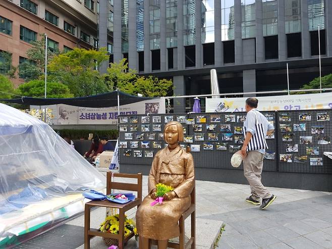 첫 일본군 '세계 위안부 피해자 기림의 날' 맞이해 서울 종로구에서 퍼포먼스를 준비하고 있는 가운데 한 시민이 그 앞을 지나가고 있다. /사진=류은혁 기자