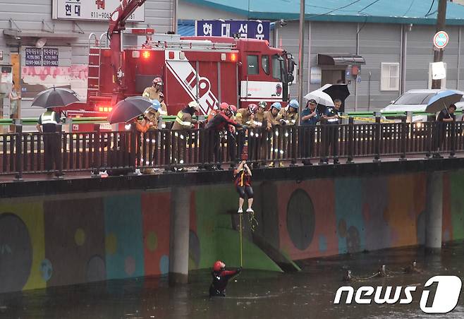 28일 오후 서울 노원구 월계동 우이천에서 노원소방서 대원들이 집중호우로 불어난 물에 의해 고립된 시민을 구조하고 있다. (노원소방서 제공) 2018.8.28/뉴스1 © News1 송원영 기자