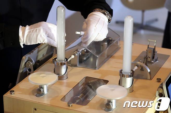 30일 오전 서울 소공동 롯데호텔에서 열린 필립모리스의 궐련형 전자담배 증기와 일반담배 연기의 폐암 발생 영향 비교 연구결과 발표회에서 관계자가 사이언스머신을 이용해 아이코스(오른쪽)와 일반담배의 연소를 비교해 보여주고 있다.2018.8.30/뉴스1 © News1 이광호 기자