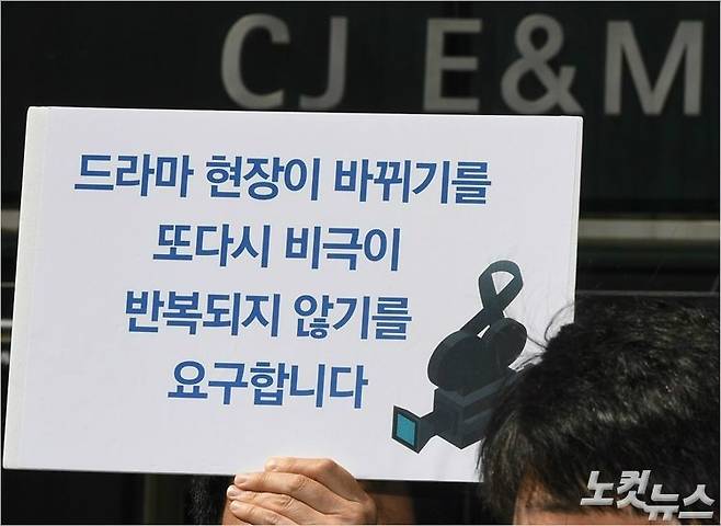 지난해 4월 24일, 서울 마포구 상암동 CJ E&M 사옥 앞에서 열린 'tvN 혼술남녀 신입조연출 사망사건 대책위원회 기자회견' 참석자들이 손피켓을 들고 있는 모습. (사진=황진환 기자 / 자료사진)
