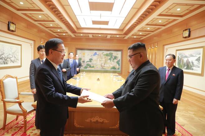 김정은 북한 국무위원장이 5일 방북한 정의용 청와대 국가안보실장에게 문재인 대통령의 친서를 전달받고 있다. 청와대 제공