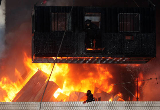 사진은 용산 참사가 발생한 2009년 1월 20일 서울 한강로 2가 재개발지역의 남일당 건물 옥상의 사고 현장. 경찰의 강제진압이 진행된 가운데 옥상에 설치한 망루에 불이 나 쓰러지고 있다. [연합뉴스]